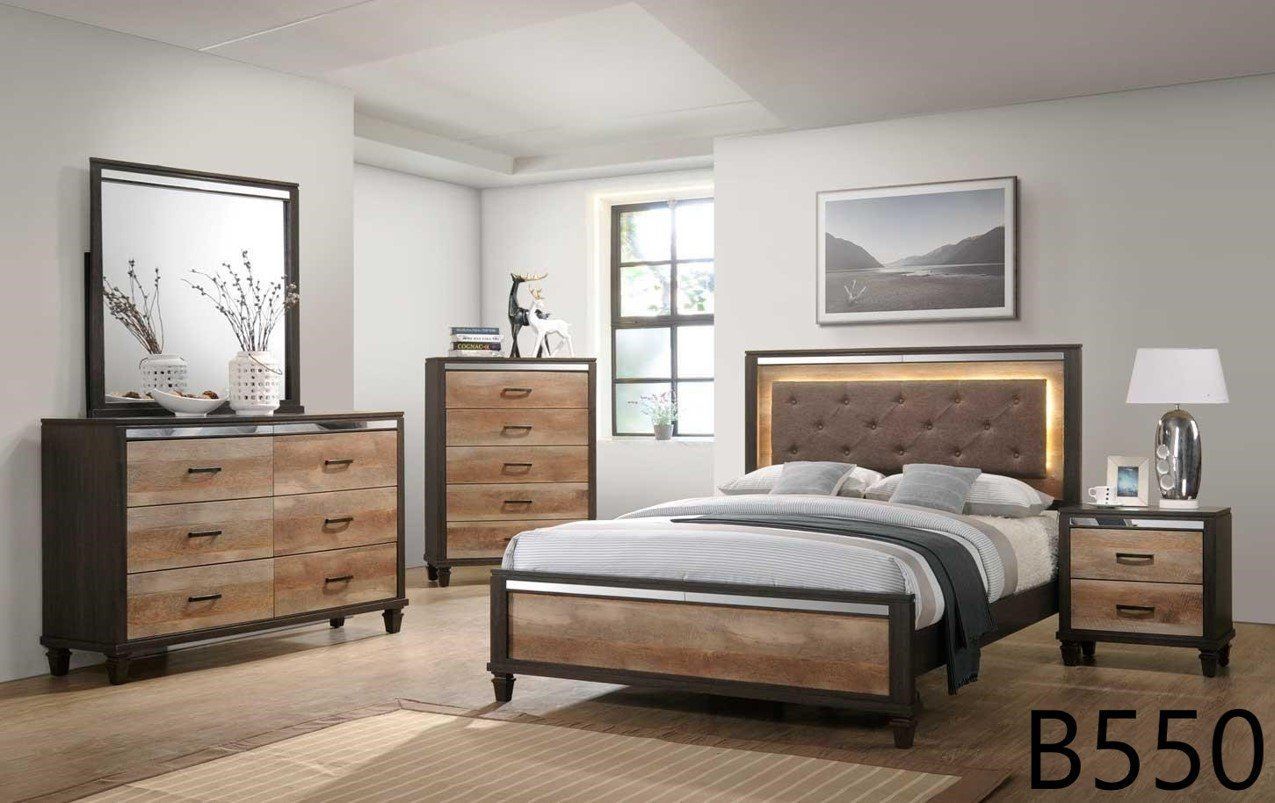 A bedroom with a bed , dresser , nightstand , mirror and lamp.