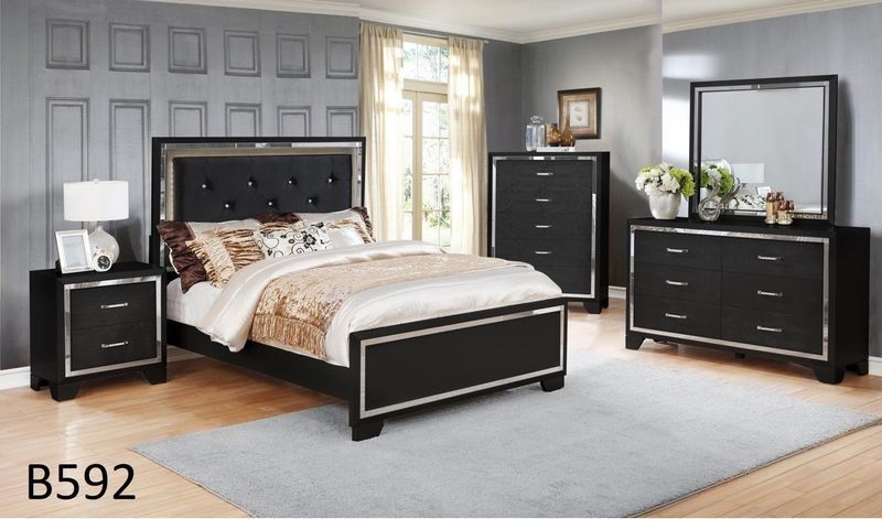 A bedroom with a bed dresser mirror and nightstand