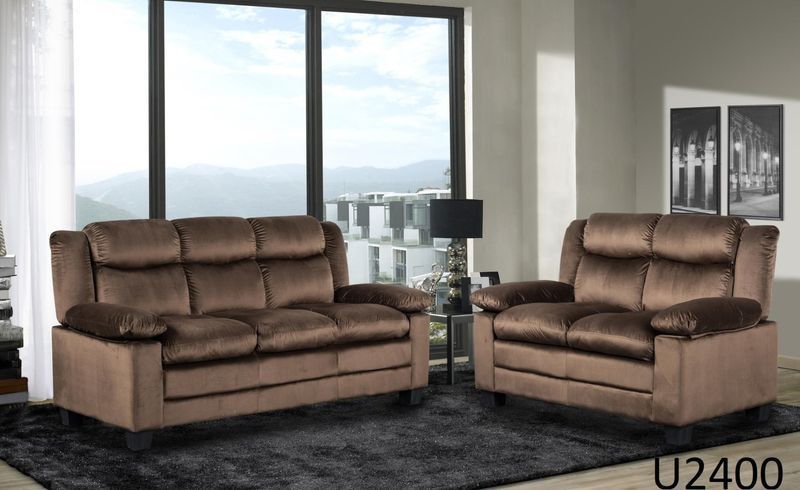 A living room with two brown couches and a rug.