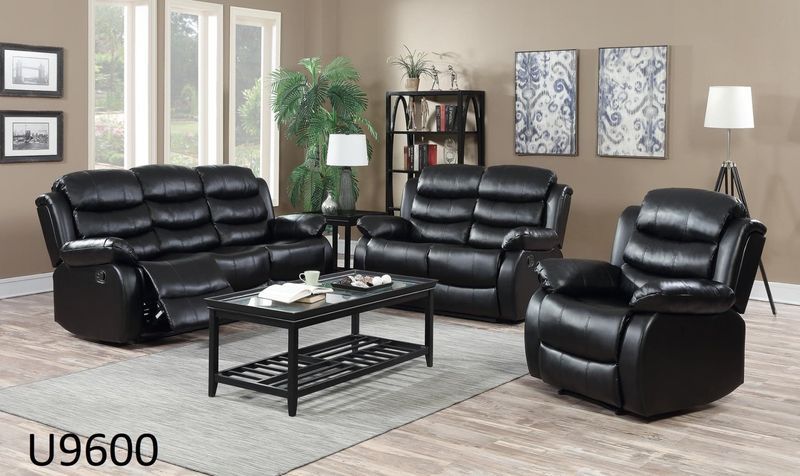 A living room with black leather furniture and a coffee table