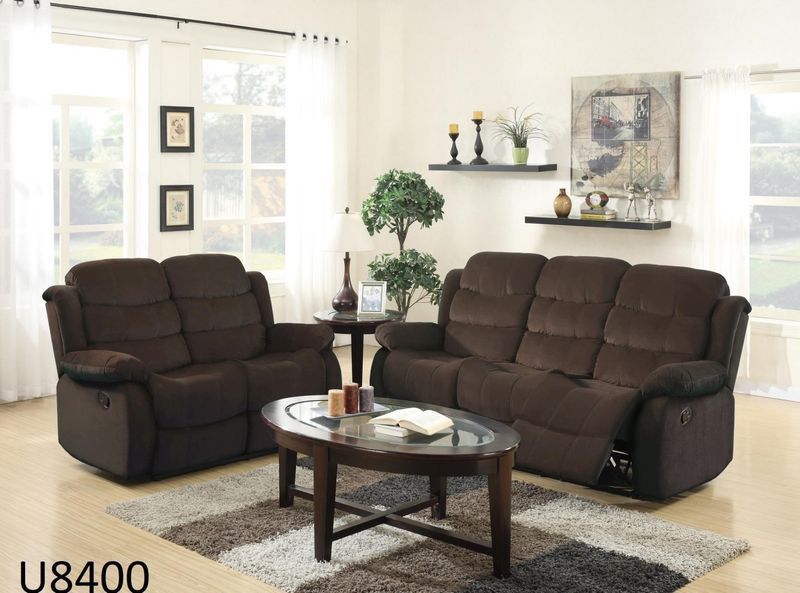 A living room with two brown couches and a coffee table
