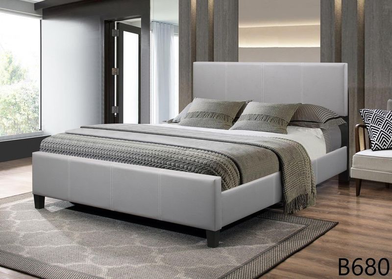 A bedroom with a bed , chair , rug and window.