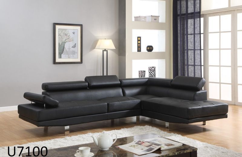 A living room with a black sectional couch and a coffee table