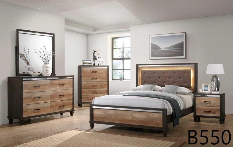 A bedroom with a bed , dresser , nightstand , mirror and lamp.