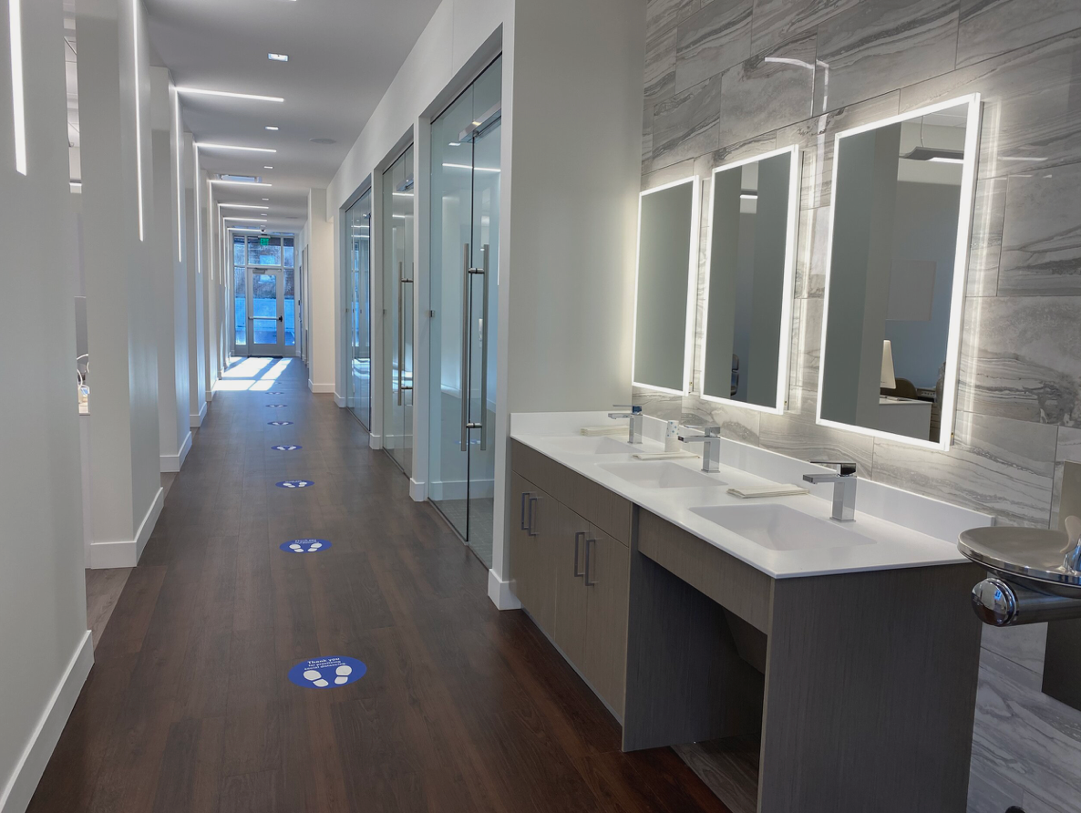 Pure Orthodontics interior... a long hallway with three sinks and mirrors in a dental office.