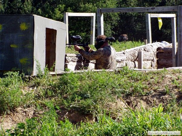 Soldier aiming a rifle behind a concrete barrier in an outdoor training area