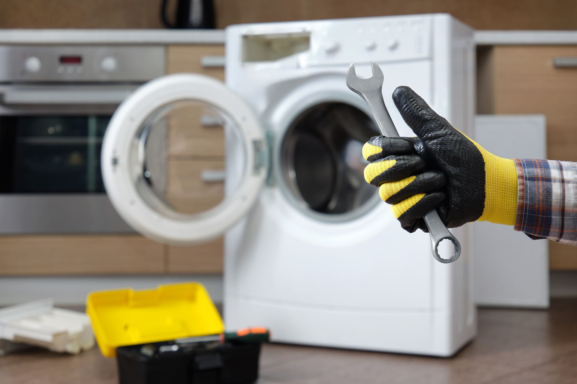 Une personne tient une clé devant une machine à laver.