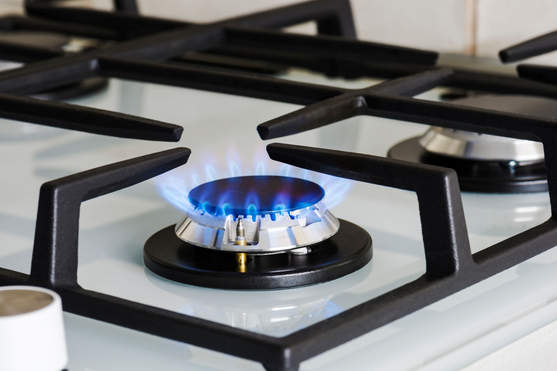 Une cuisinière à gaz avec une flamme bleue dessus.