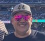 A man wearing sunglasses and a hat with the number 44 on it.
