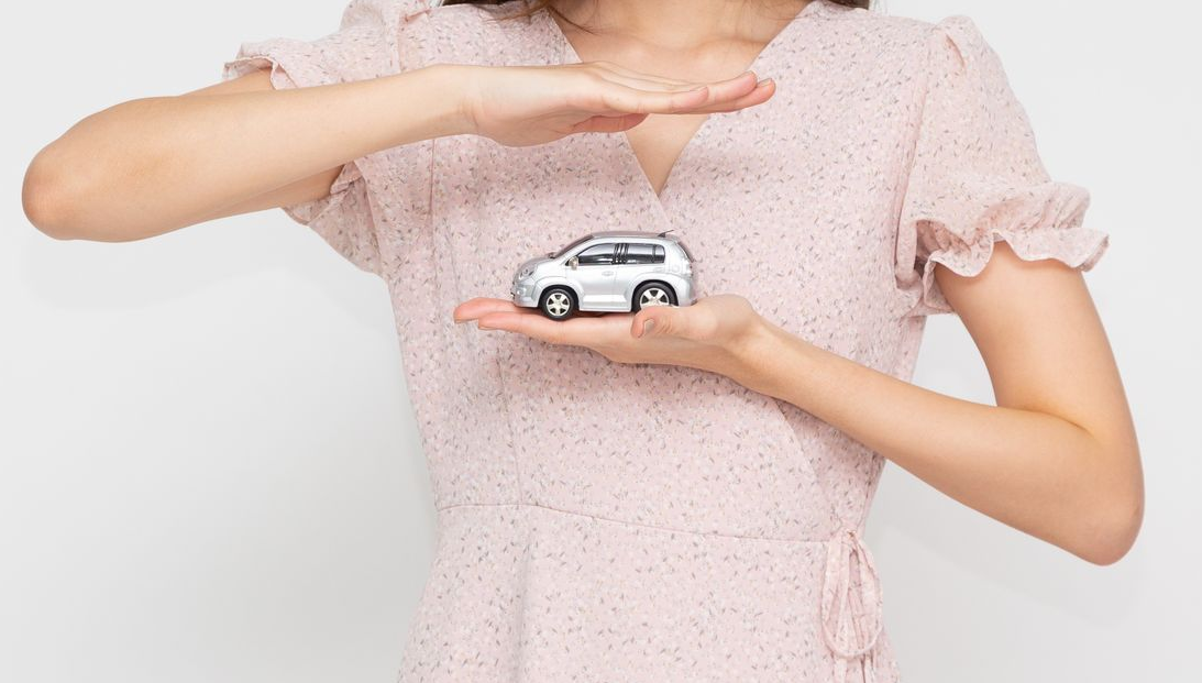A close-up of a woman holding a red toy car, symbolizing an auto insurance agent. A close-up of a woman holding a red toy car, symbolizing an auto insurance agent.