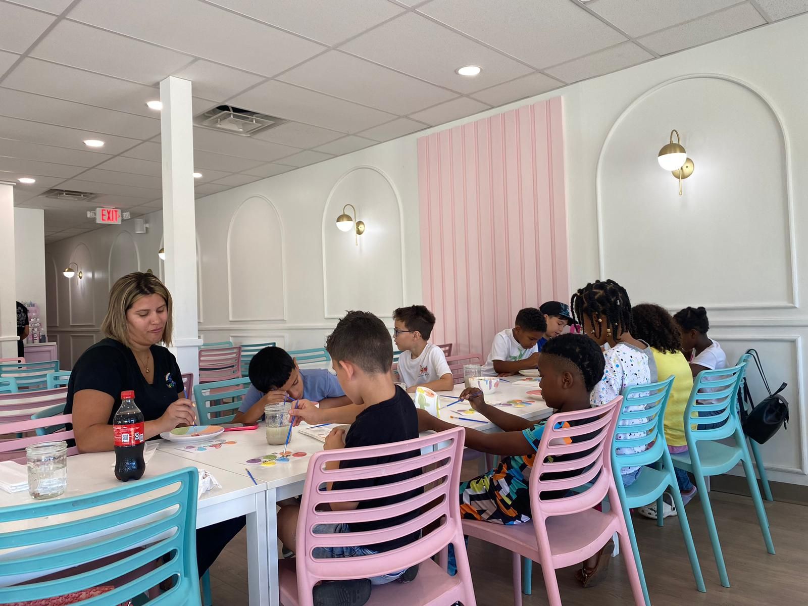 A group of children are sitting at tables in a restaurant.