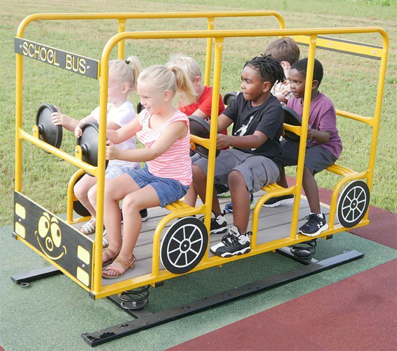 Children playing on a yellow school bus-shaped playground ride.