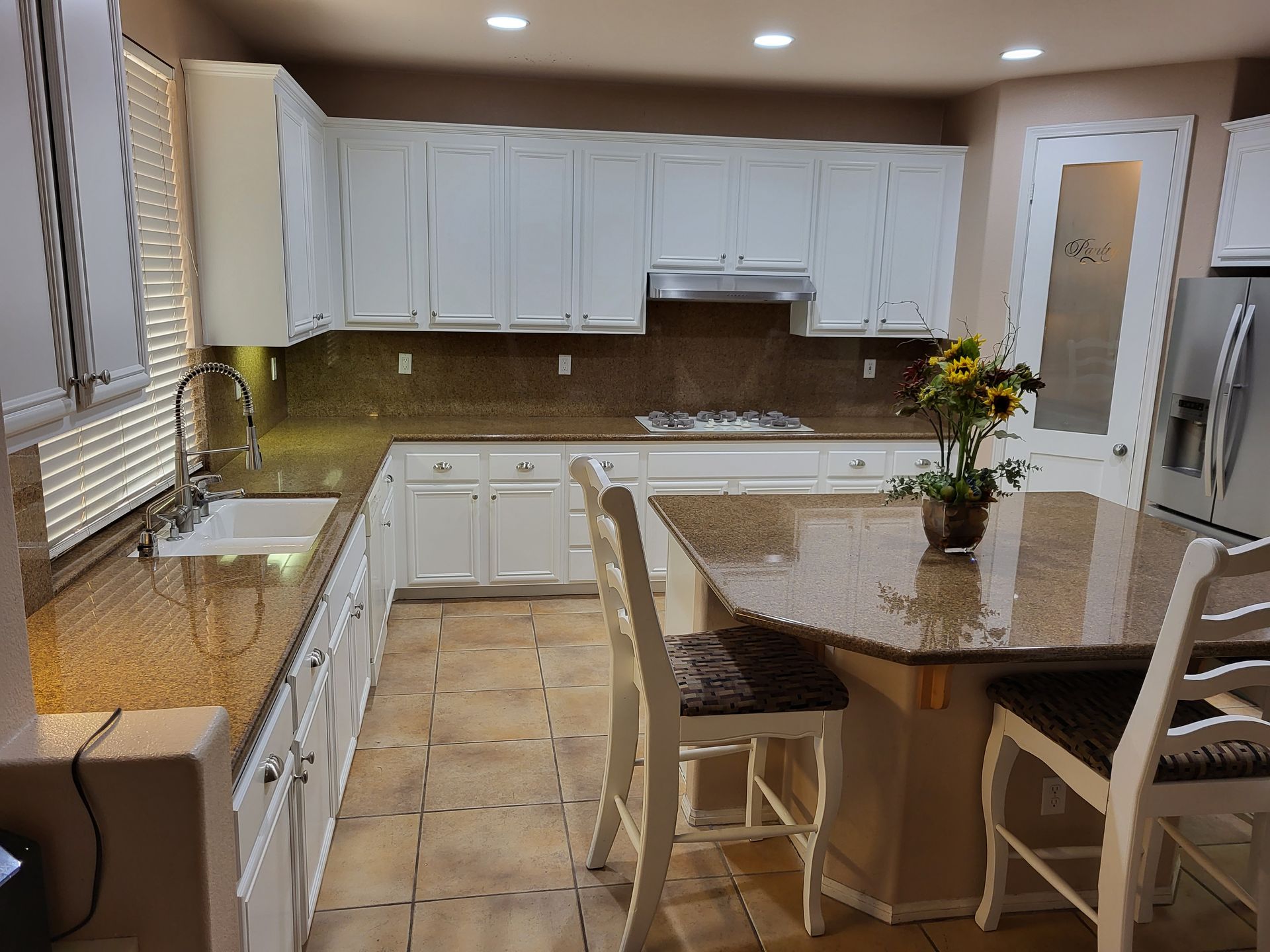 A kitchen with white cabinets and granite counter tops