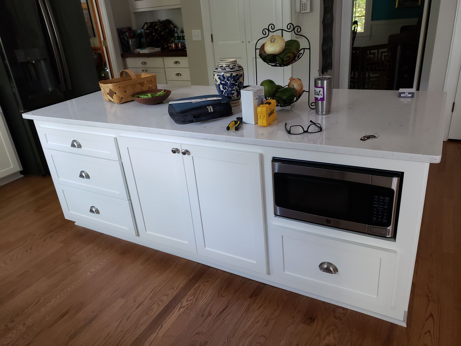 A kitchen island with a microwave and a refrigerator on it.