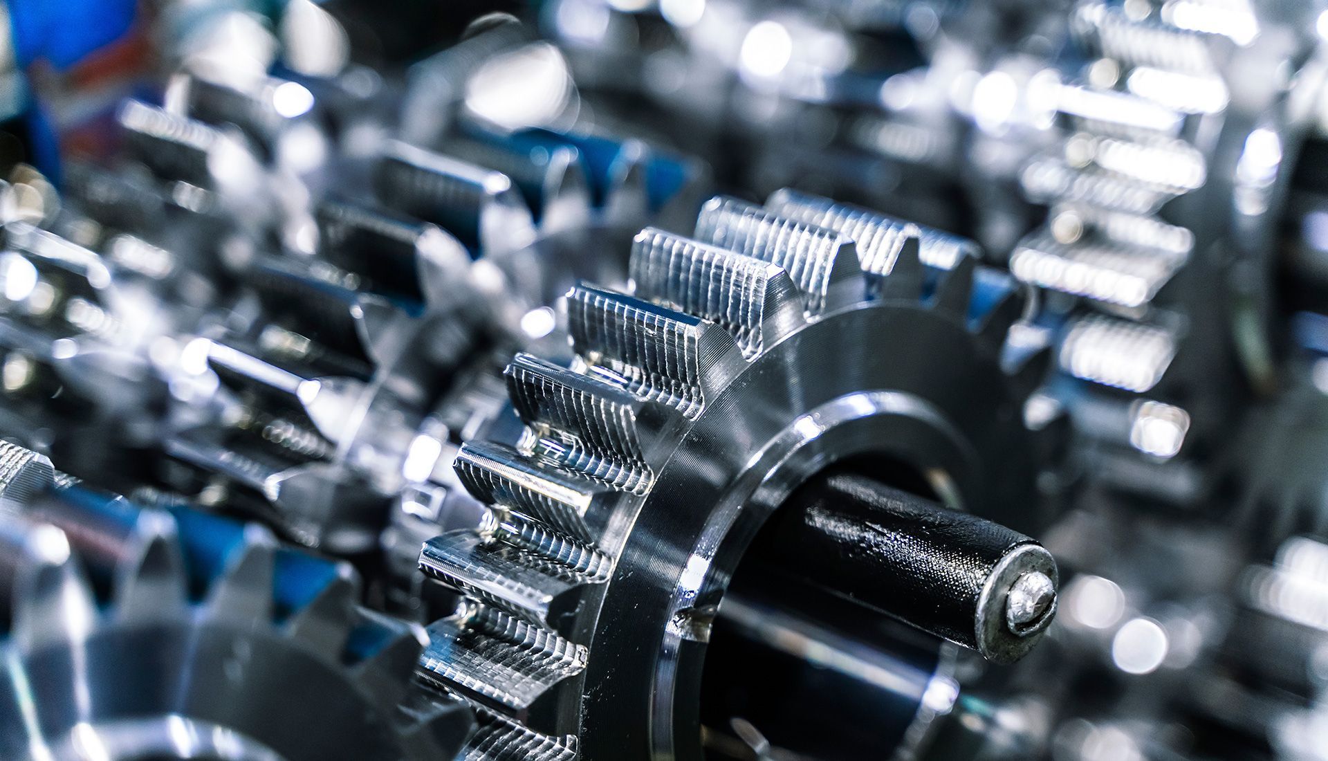 Close-up of shiny metal gears meshing together, part of a mechanical system.