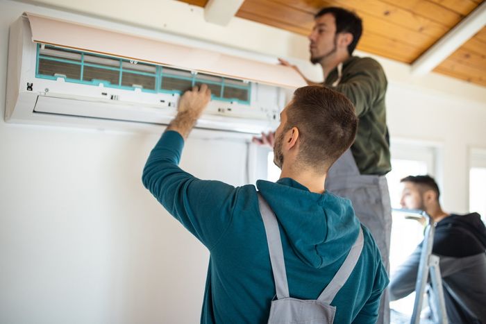 Repairman Team Installing Air Conditioner - Clarksville, IA - Wedeking Custom Comfort Repairman Team Installing Air Conditioner - Clarksville, IA - Wedeking Custom Comfort