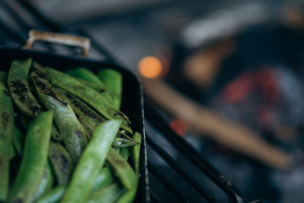 Greens being cooked over a fire.