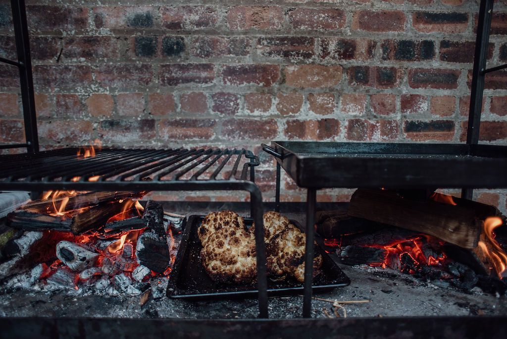 Cauliflower being cooked over open flames.