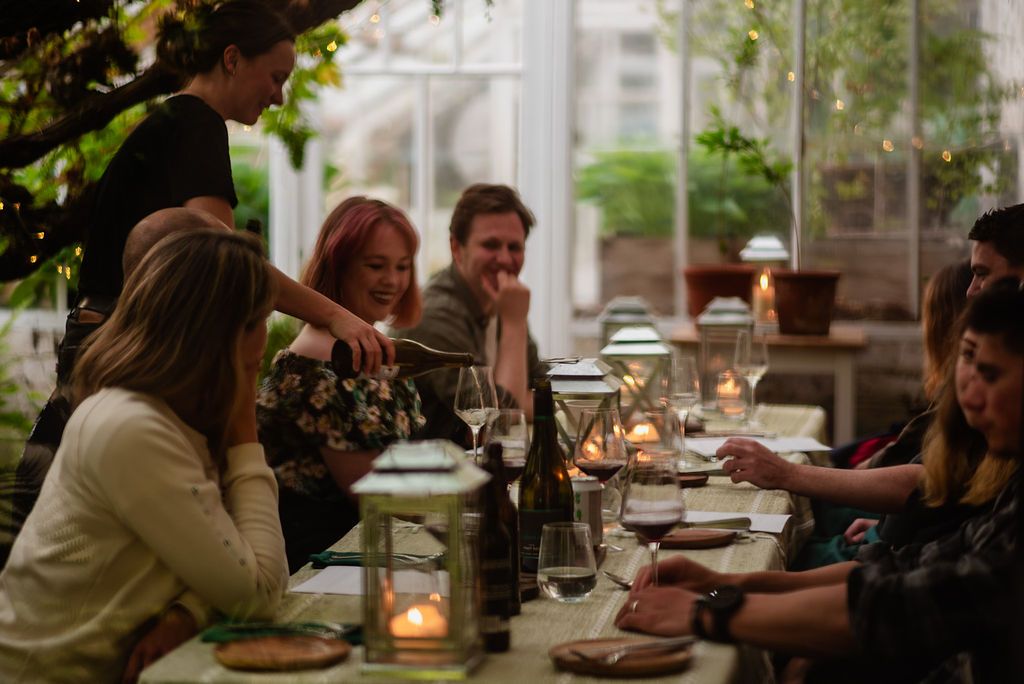 Guests on a long table enjoying Wild Kabn Kitchen.