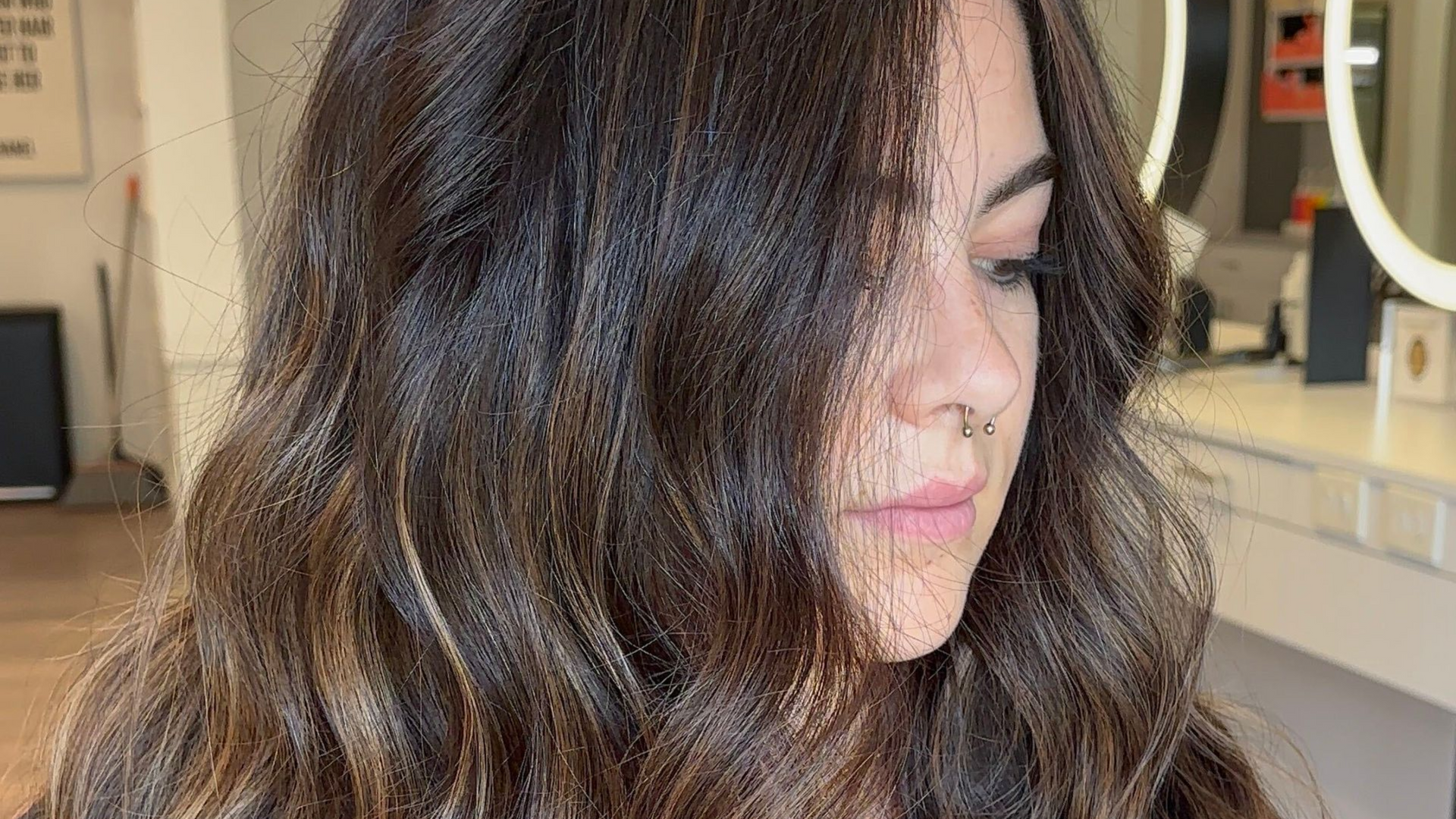 Client with rich, dimensional brunette hair and soft waves, colored and styled by Chloe Hello Hair