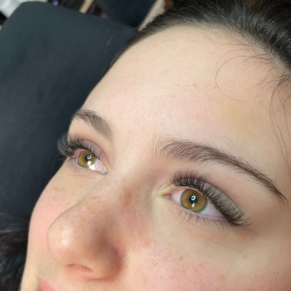 Client showing eyelash extensions and shaped eyebrows at Hello Hair Co