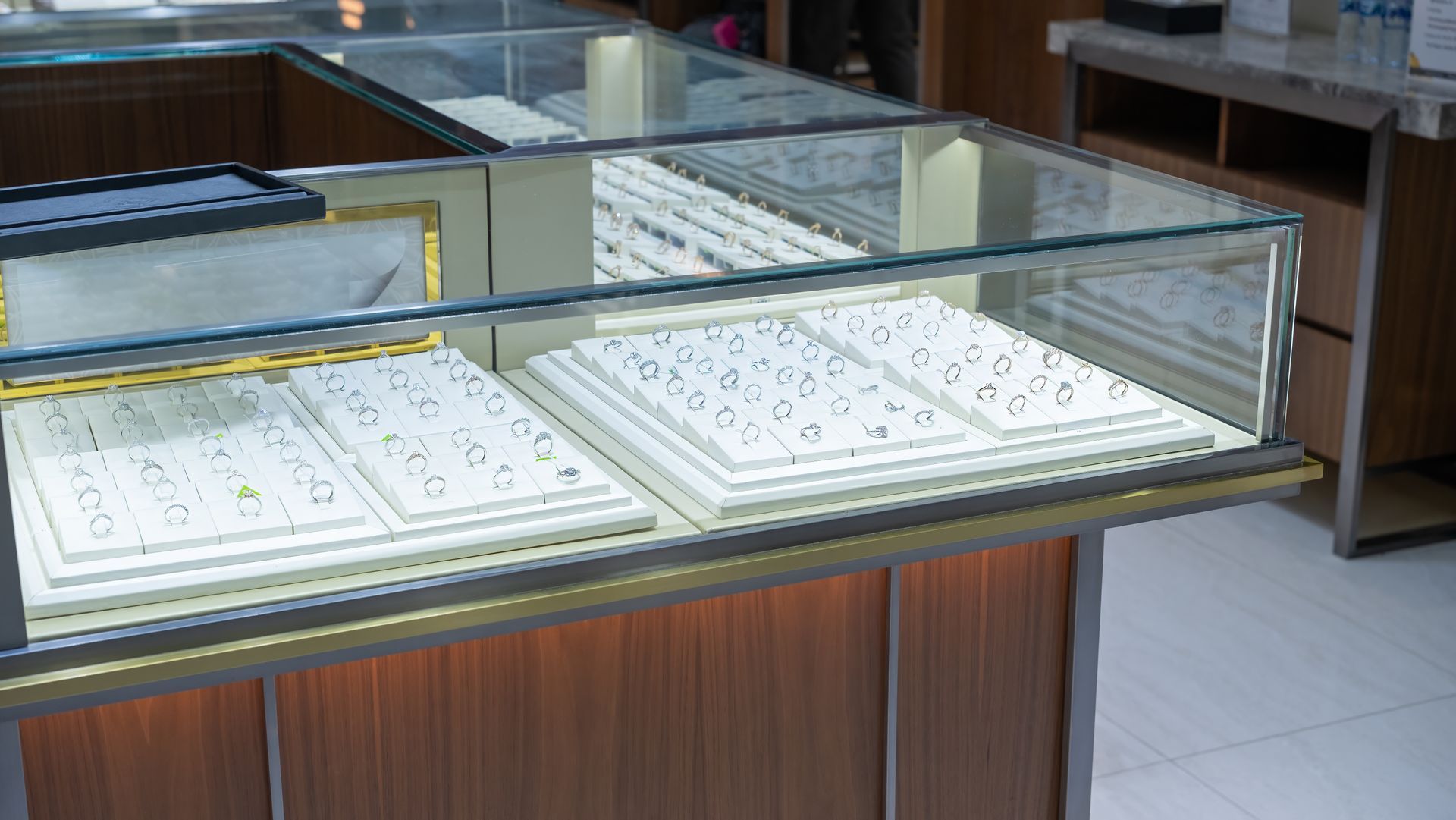 Glass display case with neatly arranged white trays and papers in a shop or office interior