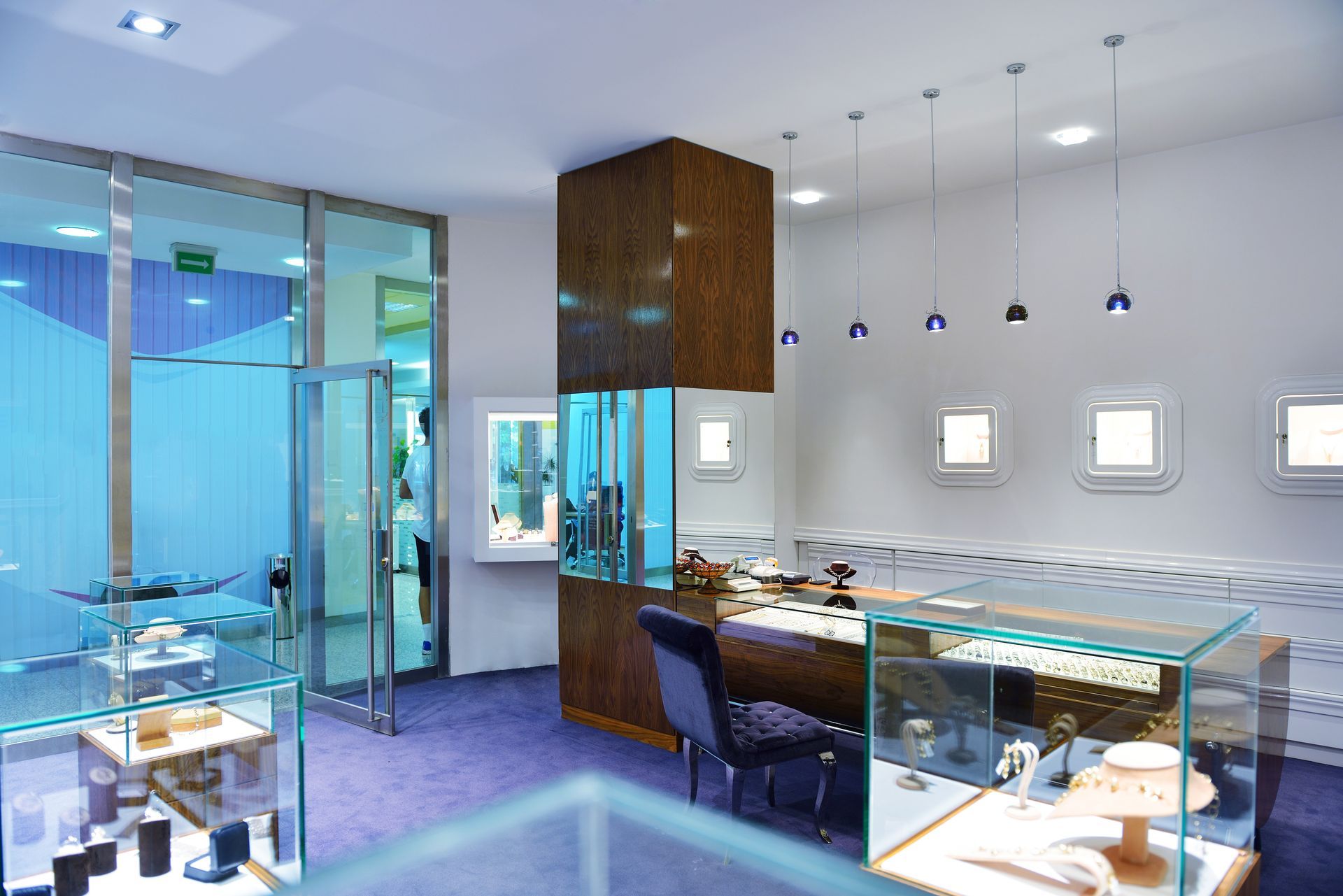 Modern bright restaurant with glass walls, blue lighting, and empty tables set with plates