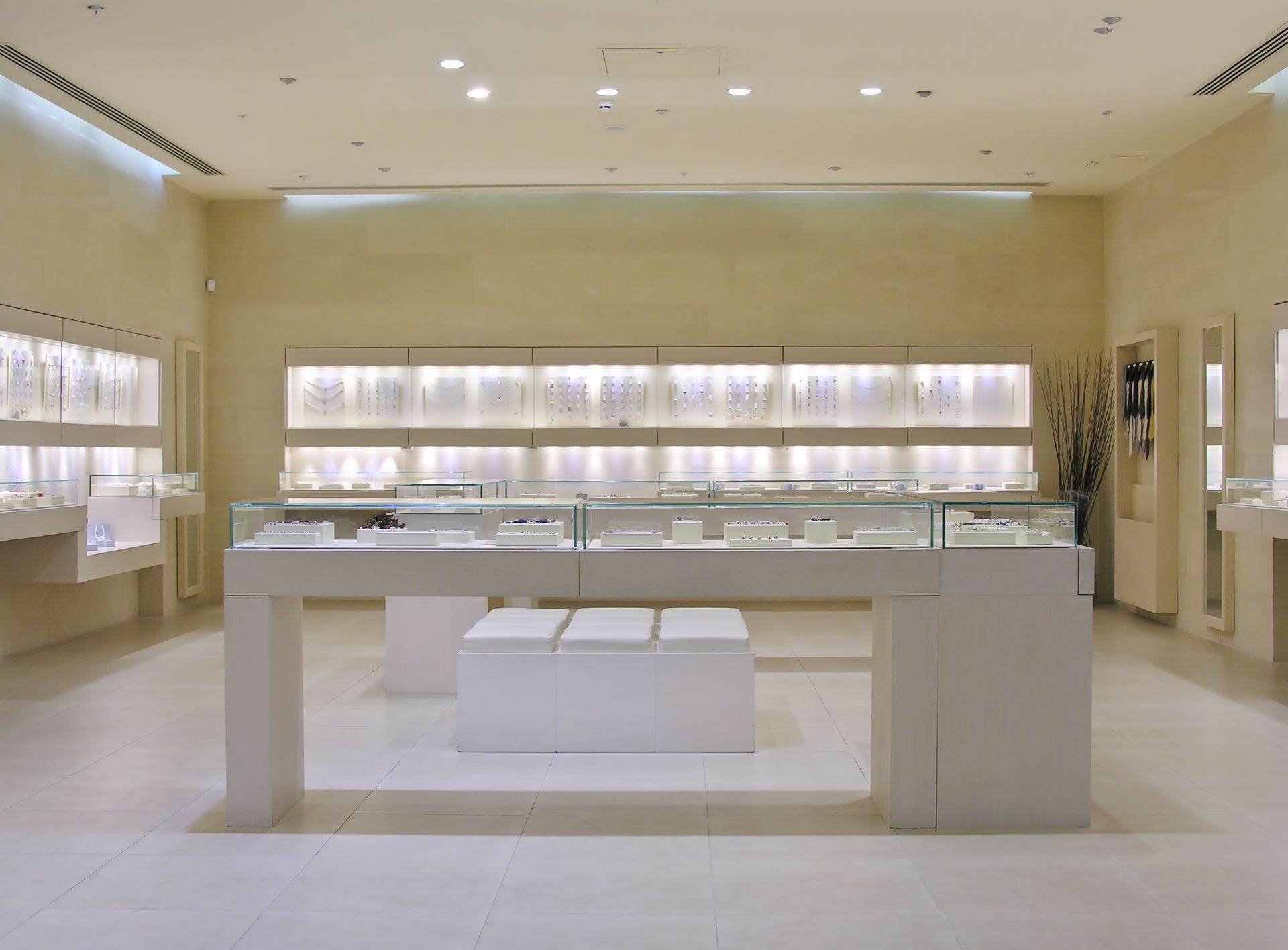 Bright minimalist jewelry store interior with glass display cases and warm wall lighting