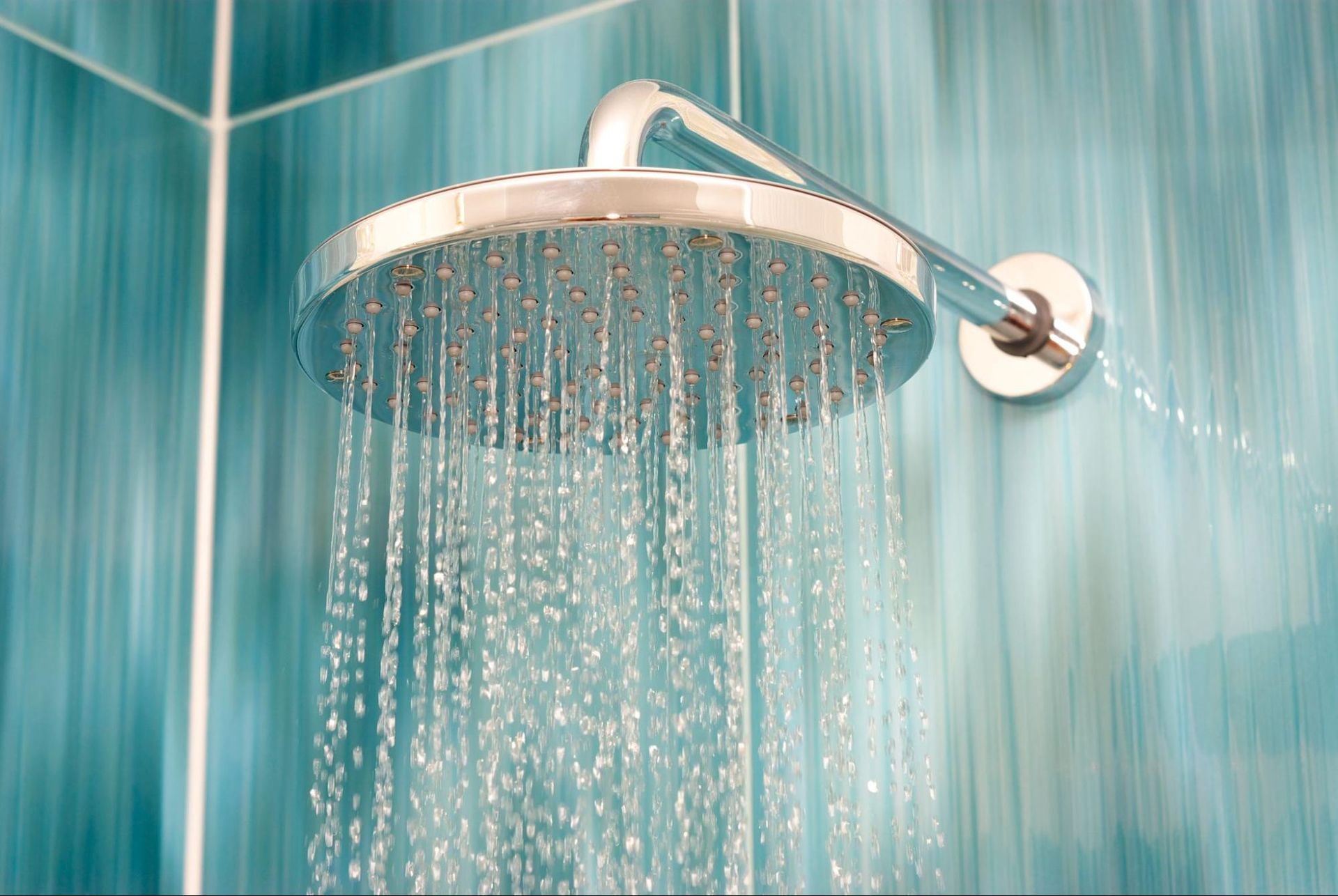 a close up of a shower head with water coming out of it in a bathroom .