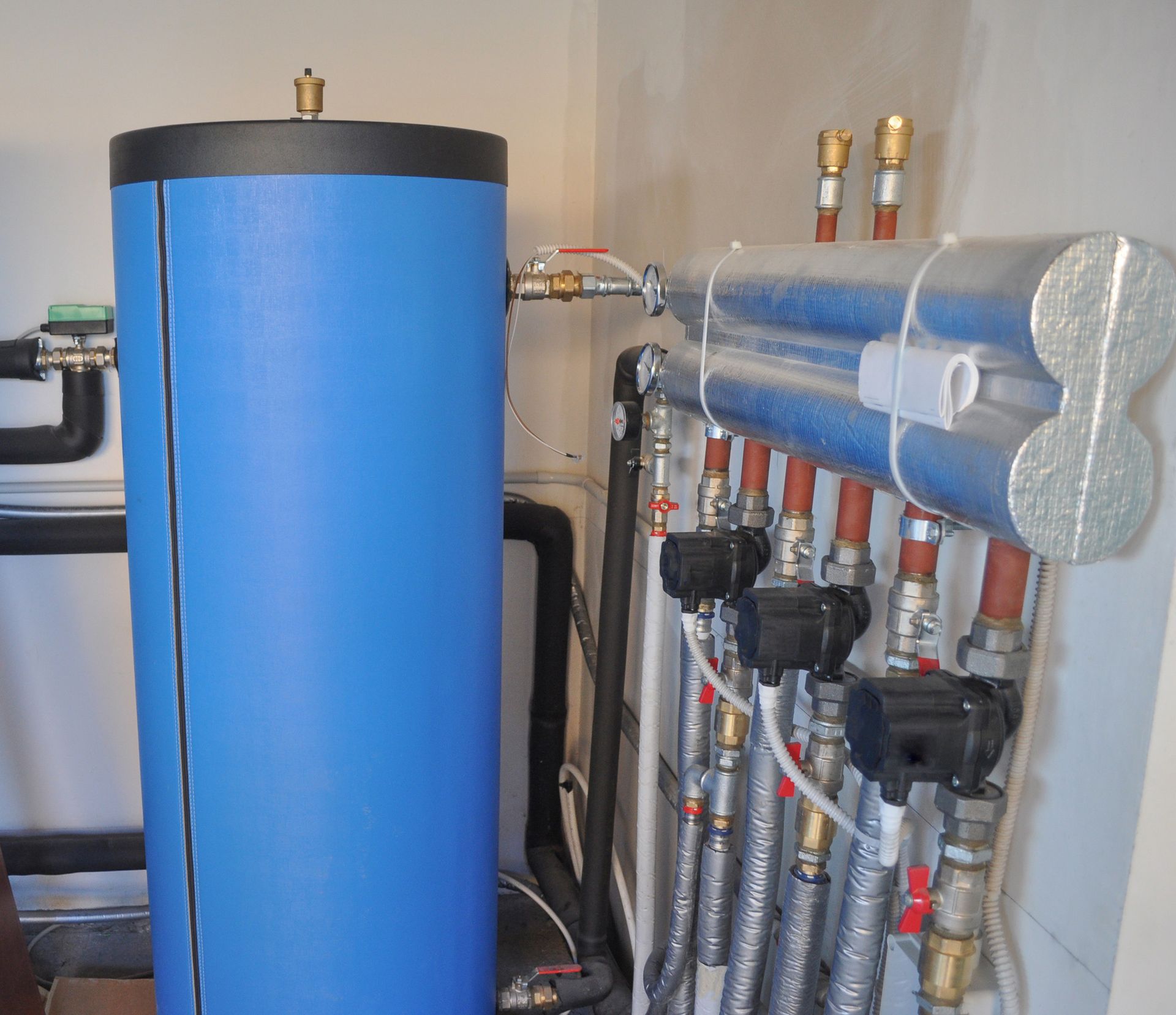 a blue cylinder is sitting next to a bunch of pipes