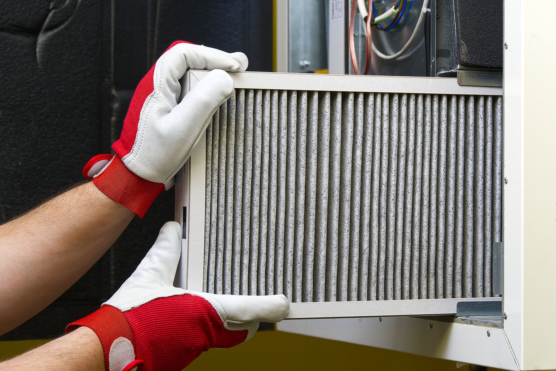 A person wearing gloves is holding a filter in their hands.