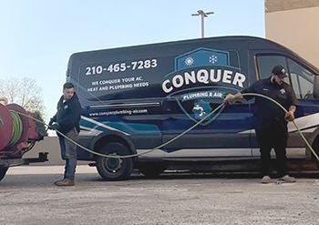 two men are standing in front of a conquer van .