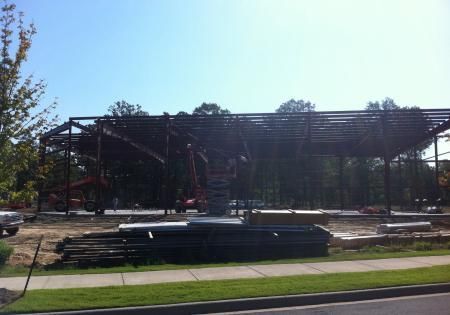 Partially built steel-framed structure at a construction site under bright sunlight
