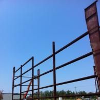 Tall metal framework under construction against a blue sky