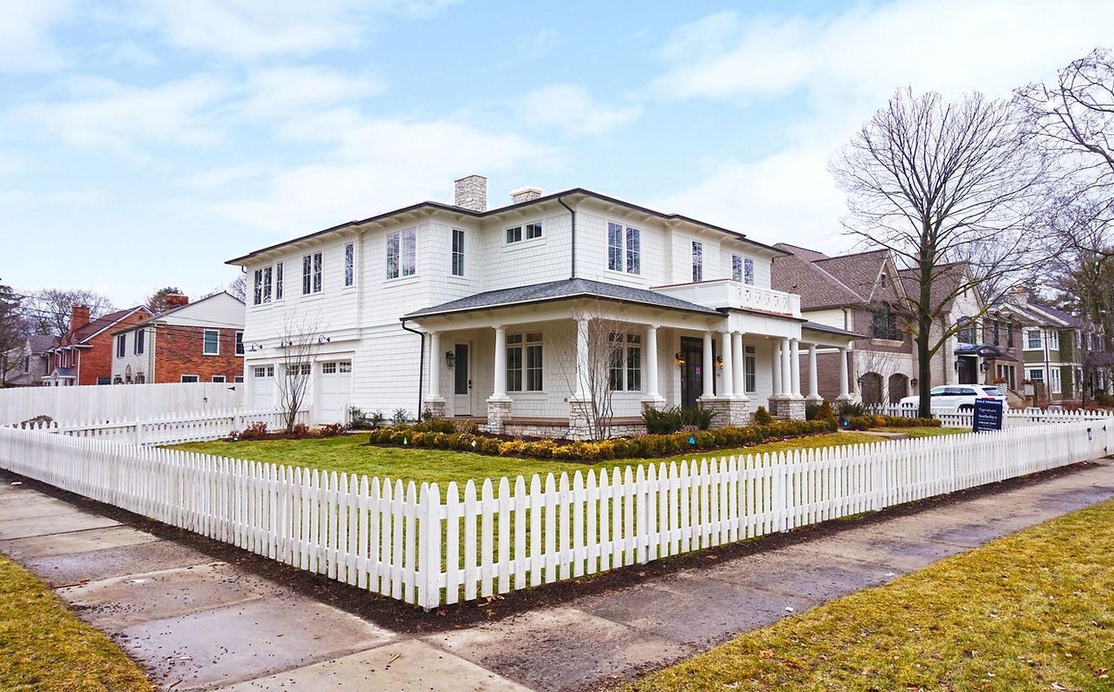 A large white house with a white picket fence around it.