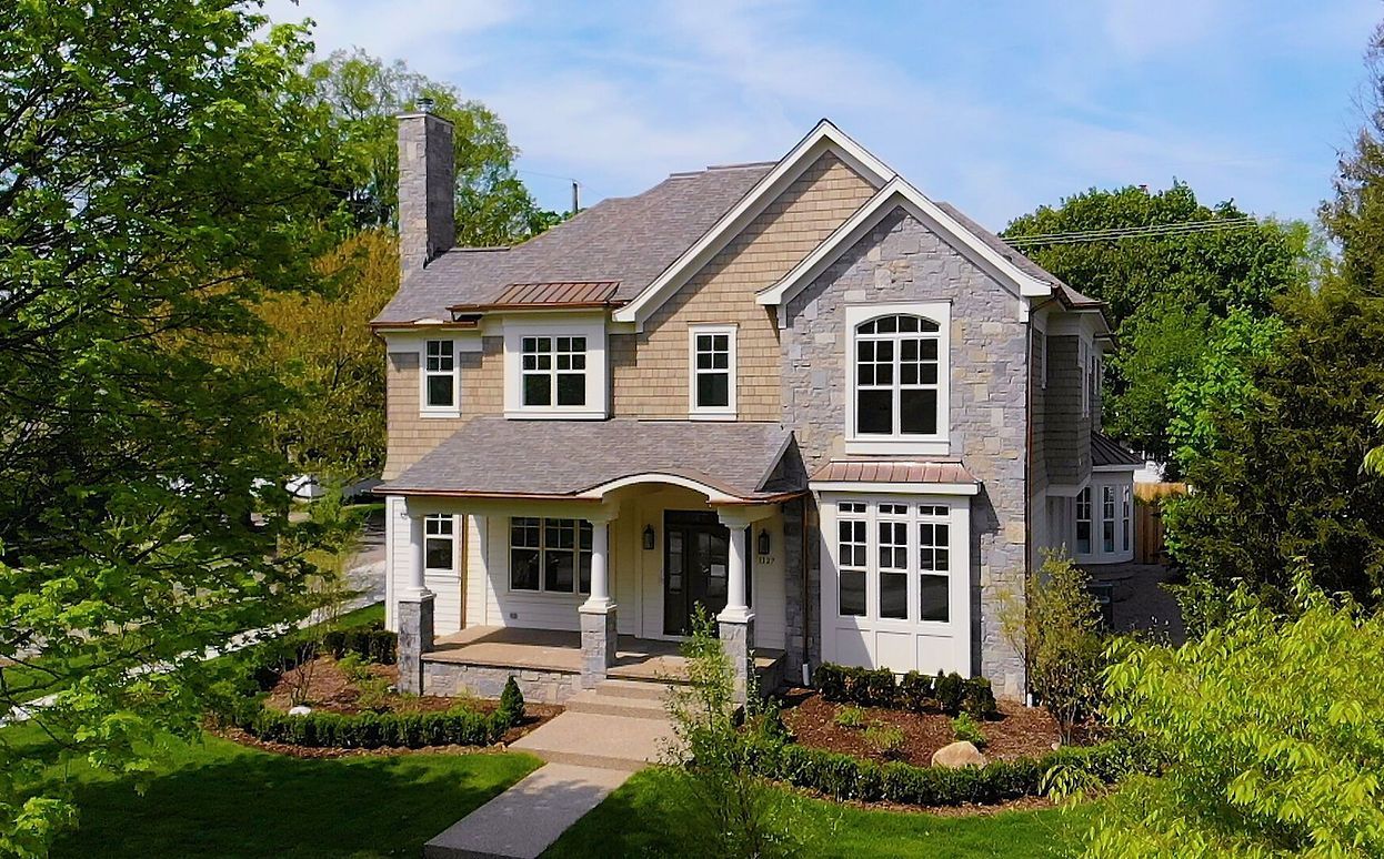 A large house with a lot of windows is surrounded by trees.