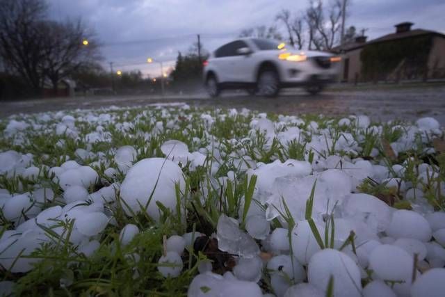 A car is driving down a road covered in hail.