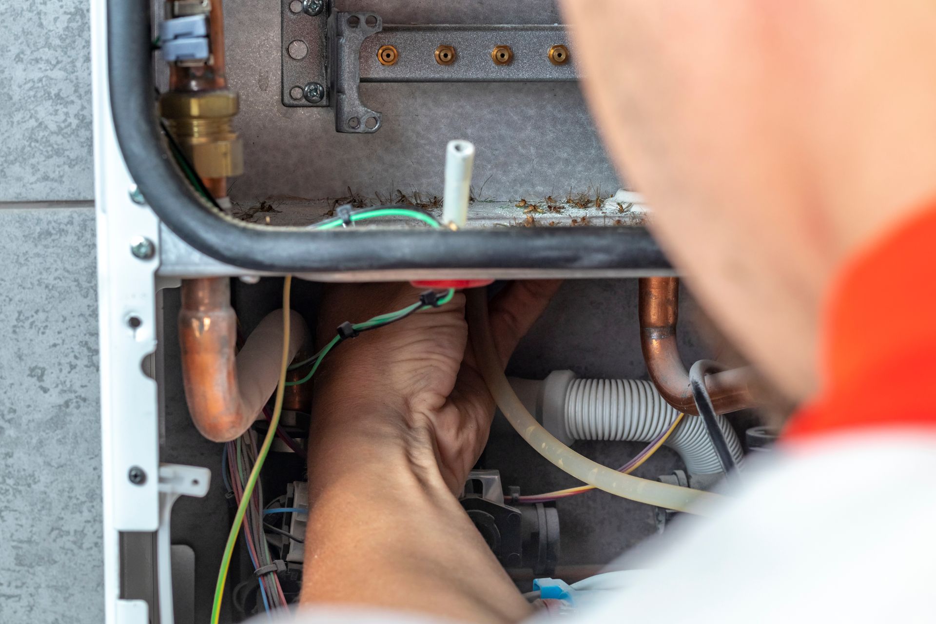 A technician inspecting a residential furnace during a repair call.
