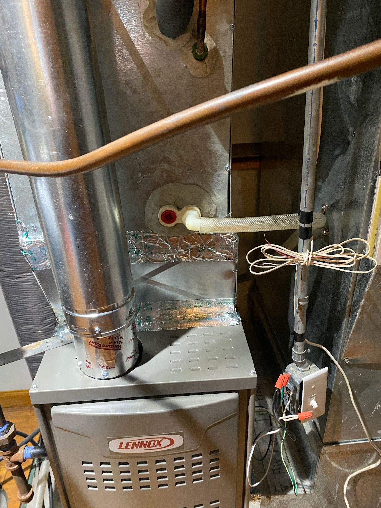 HVAC furnace and ducts in a utility closet, with copper piping and exposed wiring