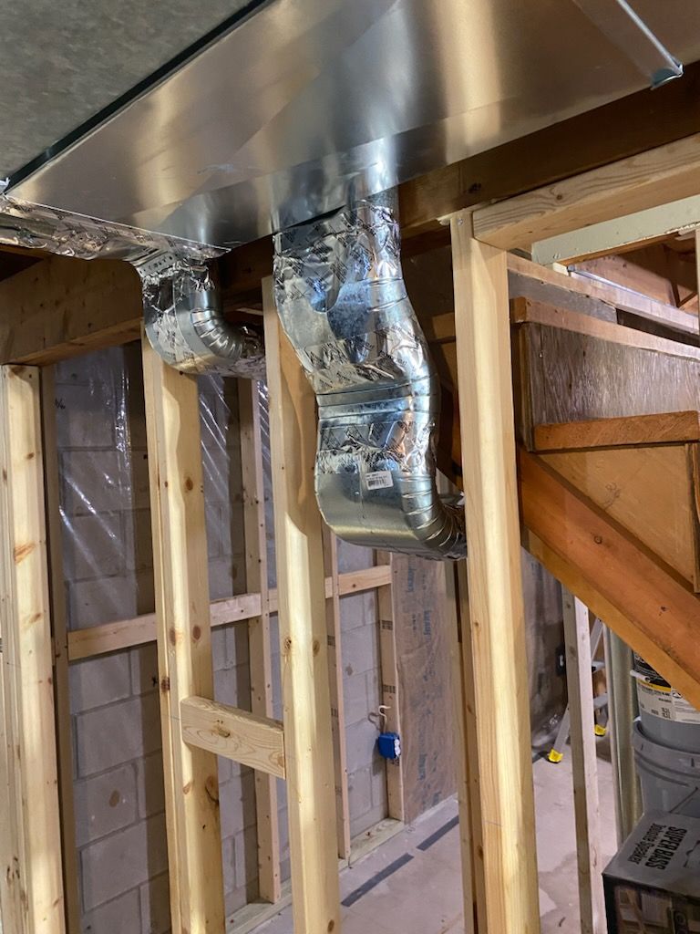 Interior framing with exposed HVAC ductwork and wooden studs in a construction area