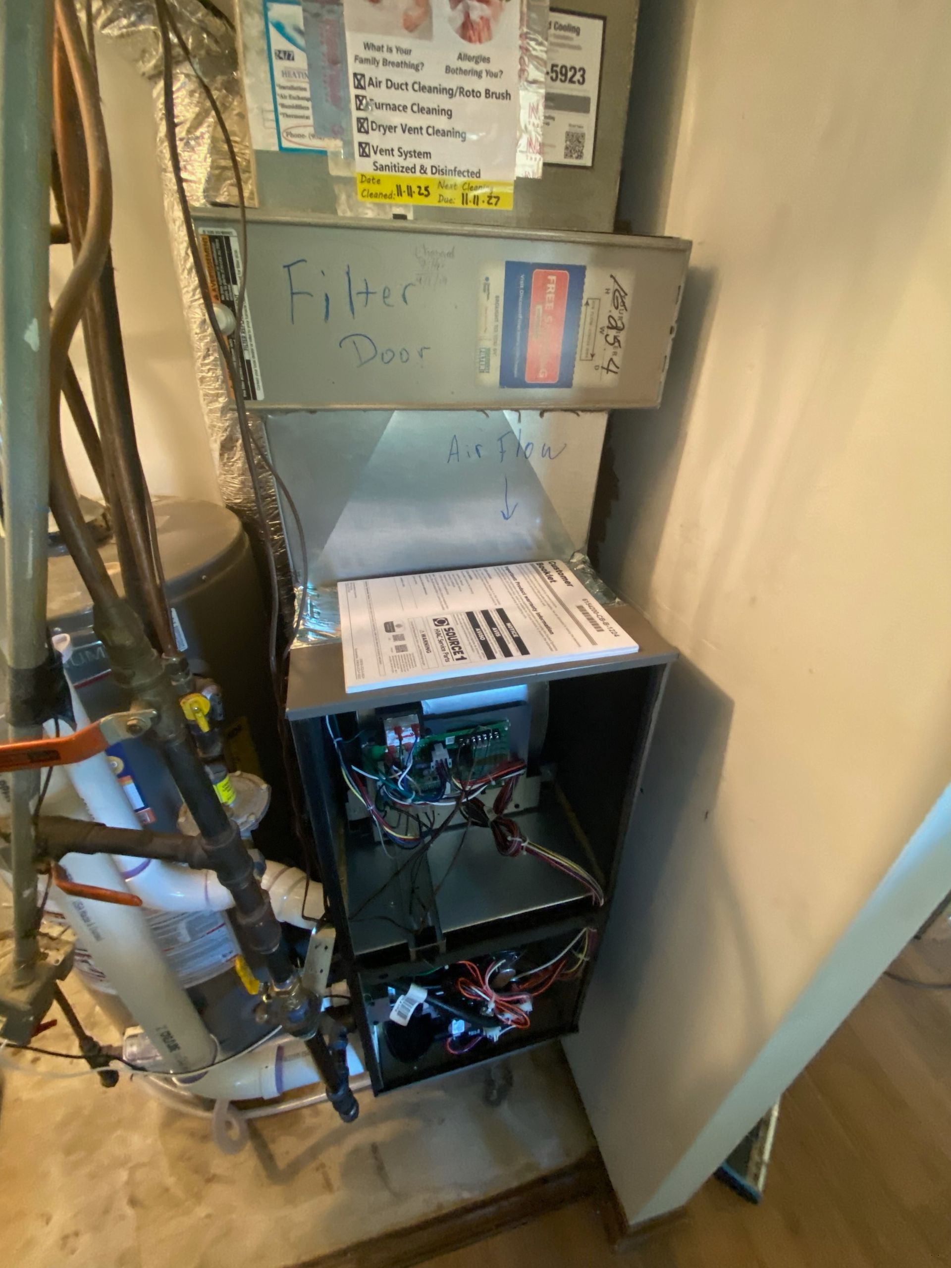Open furnace and utility area with exposed wiring and ductwork in a basement corner.