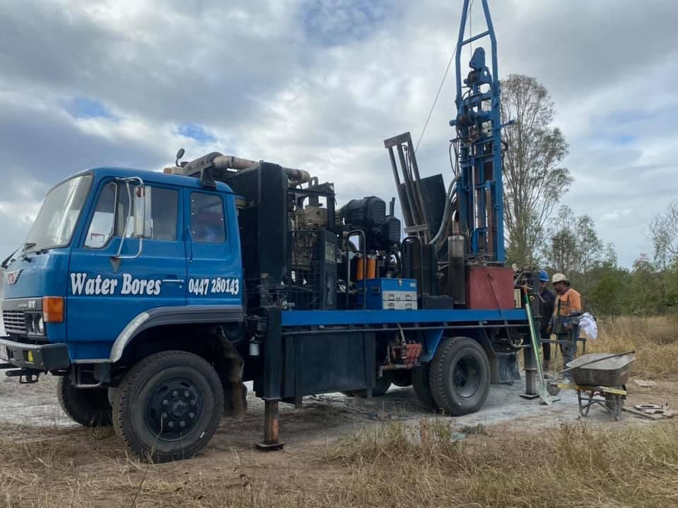 A Blue Truck is Parked in a Field With a Drilling Rig Attached to It — Cheyenne Drilling in Bundaberg, QLD