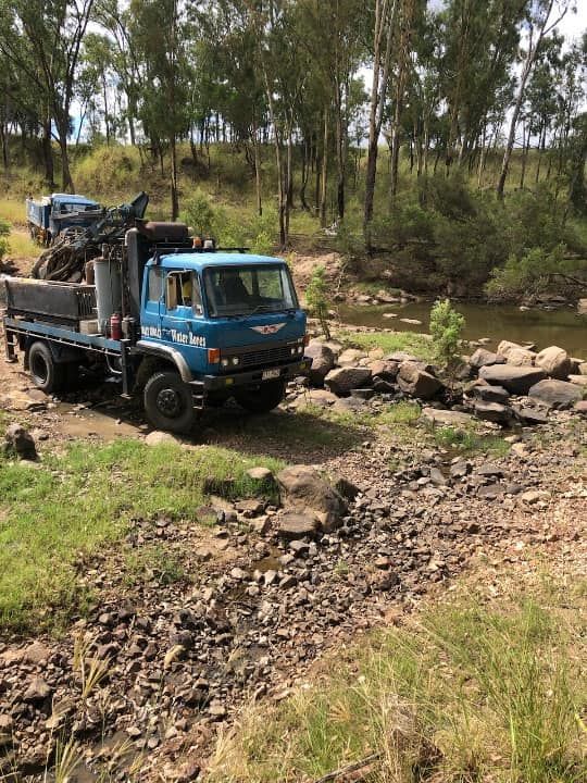 A Crane is Sitting on Top of a Truck in a Dirt Field — Cheyenne Drilling on the Sunshine Coast, QLD