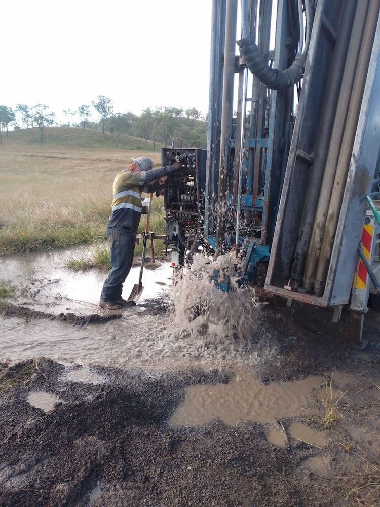 A Man is Working on a Machine in a Muddy Field — Cheyenne Drilling in Bundaberg, QLD
