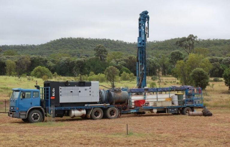 A Blue Truck With a Drilling Rig Attached to It is Parked in a Field — Cheyenne Drilling on the Sunshine Coast, QLD