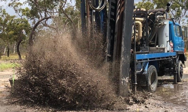A Blue Truck is Driving Through a Muddy Field — Cheyenne Drilling on the Sunshine Coast, QLD