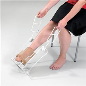 A woman is sitting on a chair putting on socks