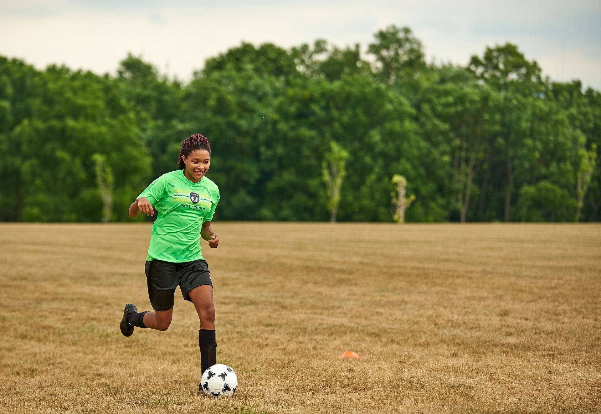A girl from the JTDF Skills School dribbling a soccer ball