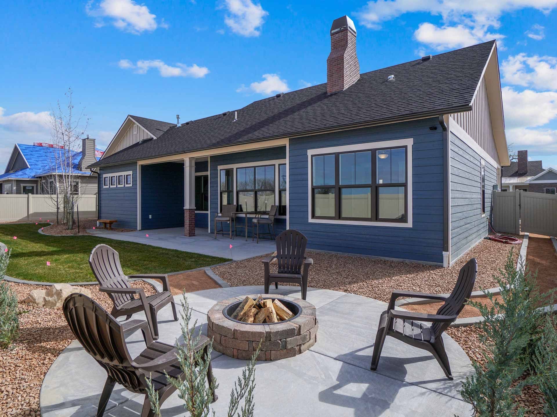 There is a fire pit in the backyard of a house