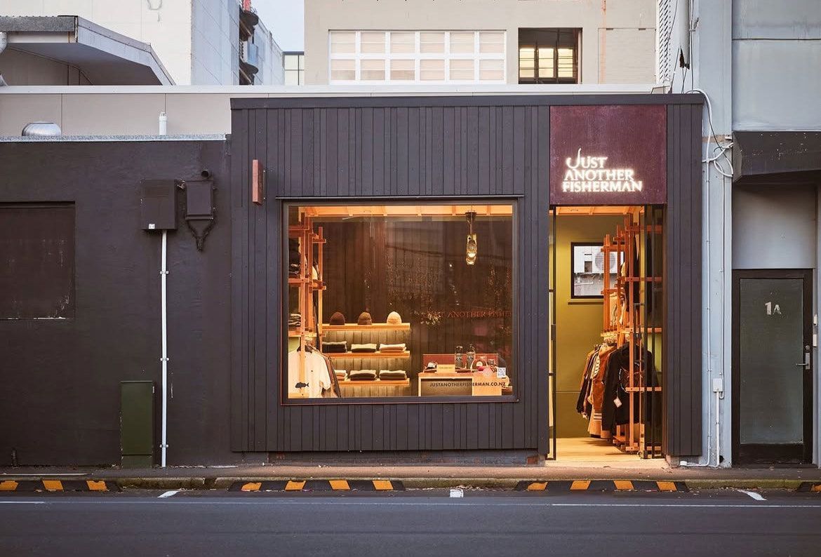 Small modern storefront with warm-lit interior and dark exterior, viewed from the street